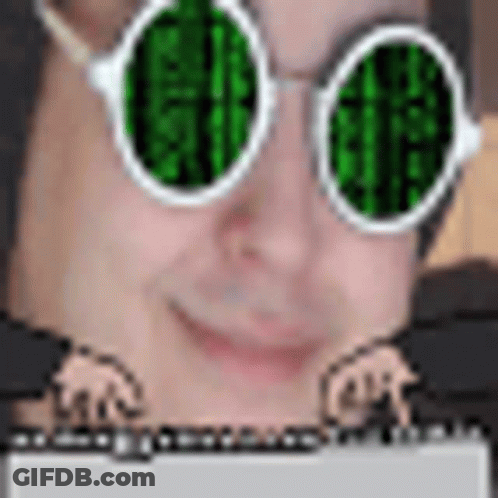 A Man Wearing Green Glasses Is Typing On A Laptop . GIF