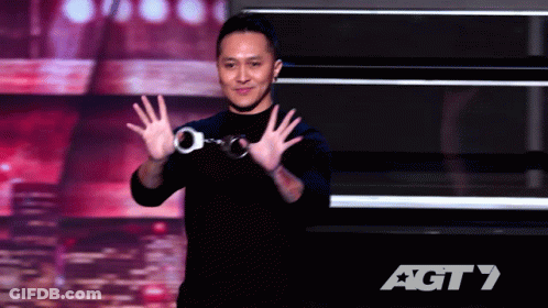 A Man Wearing Handcuffs Stands On A Stage In Front Of An Agt 7 Logo GIF