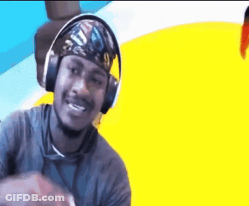 A Man Wearing Headphones And A Bandana Is Smiling . GIF