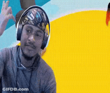 A Man Wearing Headphones And A Bandana On His Head Is Making A Peace Sign GIF