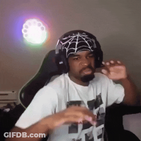 A Man Wearing Headphones And A Bandana With A Spider Web On It Is Sitting In A Chair . GIF