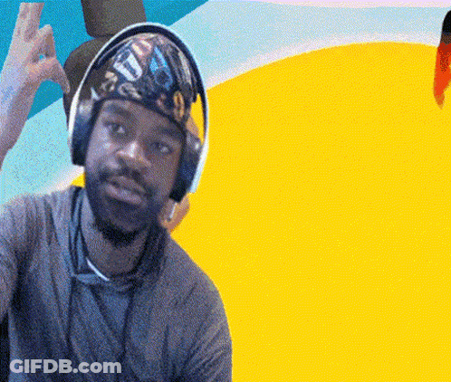 A Man Wearing Headphones And A Bandana With The Letter T On It Is Giving A Peace Sign GIF