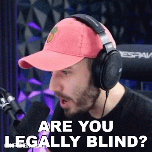 A Man Wearing Headphones And A Baseball Cap Is Talking Into A Microphone And Asking If He Is Legally Blind . GIF