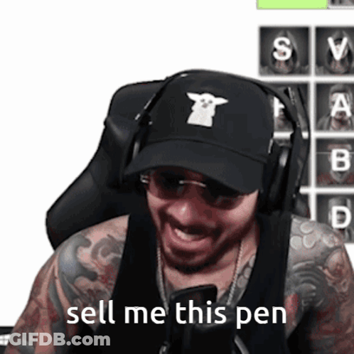 A Man Wearing Headphones And A Black Hat Says Sell Me This Pen GIF