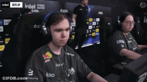 A Man Wearing Headphones And A Black Shirt With Red Bull On It GIF