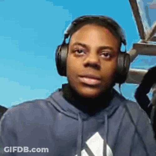 A Man Wearing Headphones And A Blue Hoodie Is Looking At The Camera GIF