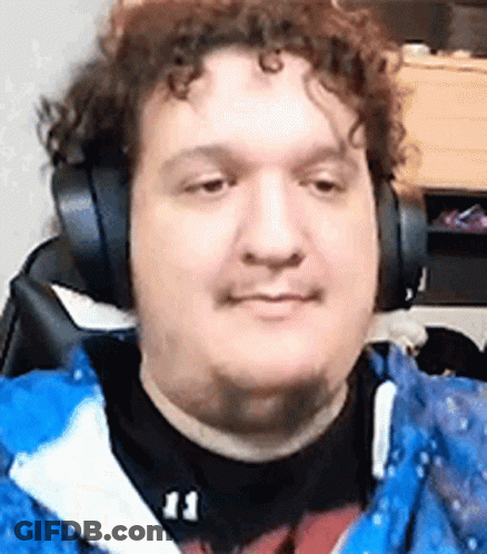 A Man Wearing Headphones And A Blue Jacket Is Sitting In Front Of A Computer . GIF