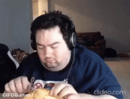 A Man Wearing Headphones And A Blue Shirt Is Eating Something GIF