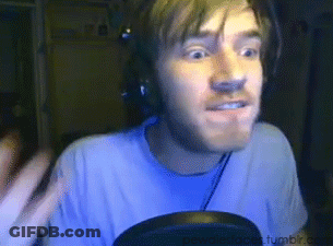 A Man Wearing Headphones And A Blue Shirt Is Looking At The Camera GIF