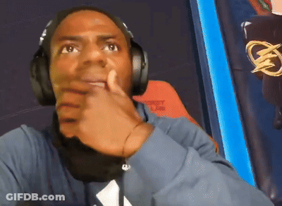 A Man Wearing Headphones And A Blue Shirt With A White Triangle On It GIF