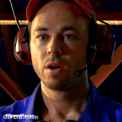 A Man Wearing Headphones And A Blue Shirt With The Hashtag #Speedracer On The Bottom GIF