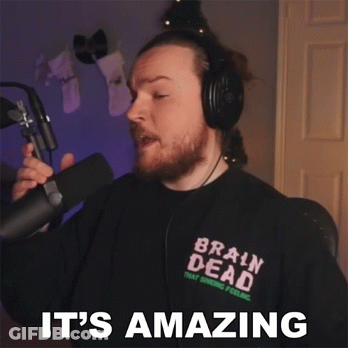 A Man Wearing Headphones And A Brain Dead Shirt Is Holding A Microphone And Says It 'S Amazing GIF