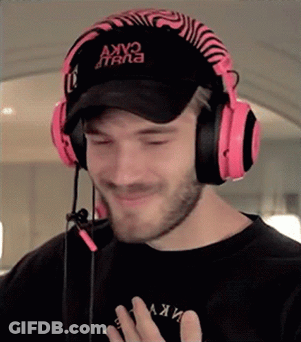 A Man Wearing Headphones And A Hat Is Making A Face . GIF