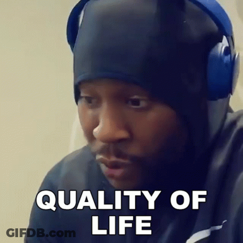 A Man Wearing Headphones And A Hat Is Making A Funny Face And Saying Quality Of Life . GIF