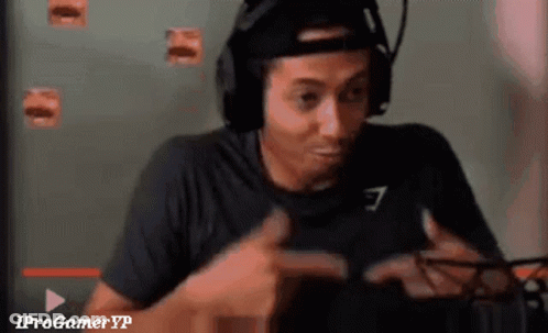 A Man Wearing Headphones And A Hat Is Playing A Video Game And Giving A Thumbs Up . GIF