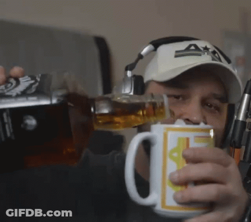 A Man Wearing Headphones And A Hat Is Pouring A Drink Into A Mug That Has The Letter A On It GIF
