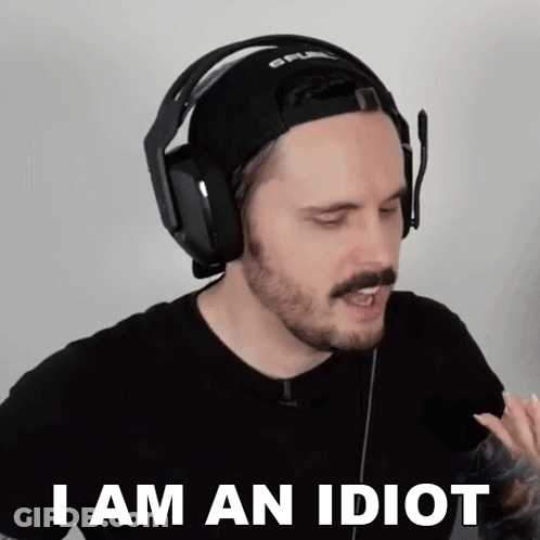 A Man Wearing Headphones And A Hat Is Saying " I Am An Idiot " GIF