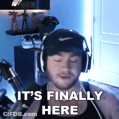 A Man Wearing Headphones And A Hat Is Saying It 'S Finally Here GIF