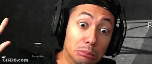 A Man Wearing Headphones And A Hat Making A Funny Face . GIF
