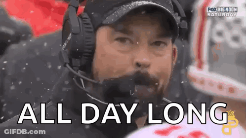 A Man Wearing Headphones And A Hat Says `` All Day Long '' During A Football Game . GIF