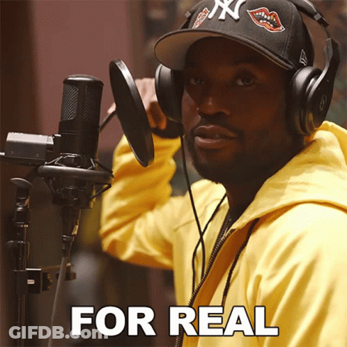 A Man Wearing Headphones And A Hat Stands In Front Of A Microphone With The Words " For Real " Written Below Him GIF