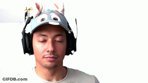 A Man Wearing Headphones And A Hat Sticking His Tongue Out . GIF