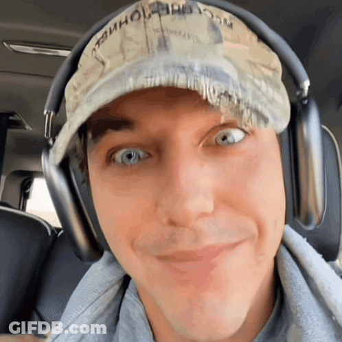A Man Wearing Headphones And A Hat That Says " Washington " On It GIF