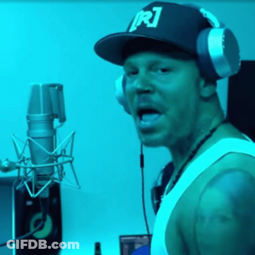 A Man Wearing Headphones And A Hat With R1 On It GIF