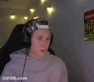 A Man Wearing Headphones And A Hat With Tape On It Is Sitting In Front Of A Sign That Says Danger . GIF
