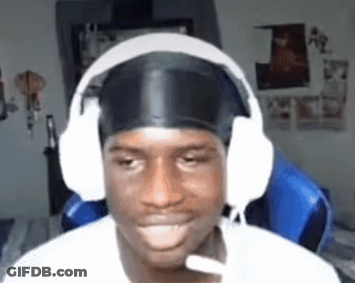 A Man Wearing Headphones And A Headband Is Sitting In A Chair And Smiling . GIF