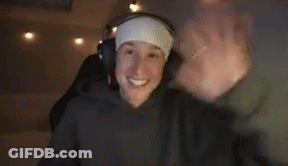 A Man Wearing Headphones And A Headband Is Waving His Hand . GIF