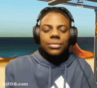 A Man Wearing Headphones And A Hoodie Is Looking At The Camera . GIF