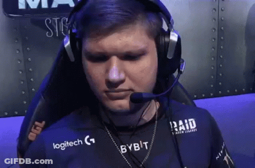 A Man Wearing Headphones And A Logitech Shirt Is Sitting In A Chair With A Microphone . GIF