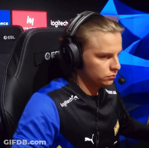 A Man Wearing Headphones And A Logitech Shirt Sits In A Gaming Chair GIF