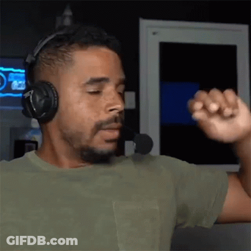 A Man Wearing Headphones And A Microphone Is Dancing In Front Of A Computer Screen . GIF