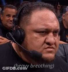 A Man Wearing Headphones And A Microphone Is Sitting In A Stadium . GIF
