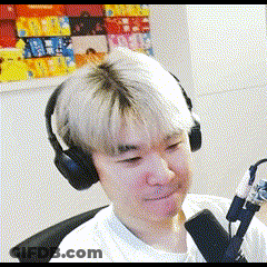 A Man Wearing Headphones And A Microphone Is Sitting In Front Of A Painting . GIF