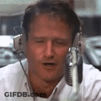 A Man Wearing Headphones And A Microphone Is Talking Into A Microphone . GIF