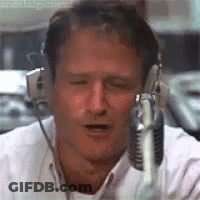 A Man Wearing Headphones And A Microphone Is Talking Into A Microphone . GIF