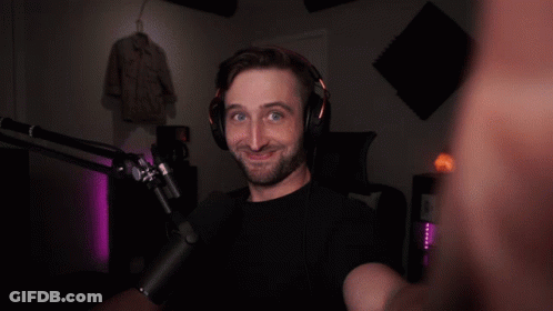 A Man Wearing Headphones And A Microphone Looks At The Camera GIF