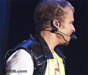 A Man Wearing Headphones And A Microphone Looks To His Left GIF
