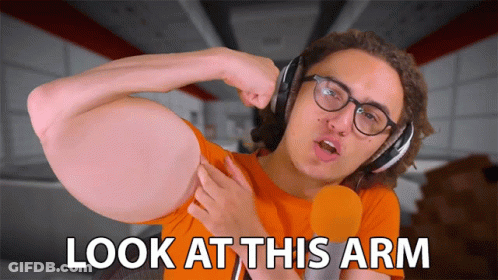 A Man Wearing Headphones And A Microphone Says " Look At This Arm " GIF