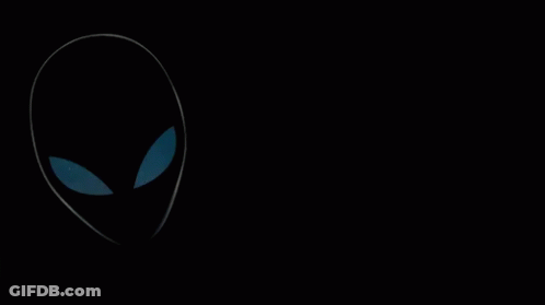 A Man Wearing Headphones And A Monster Shirt Stands In Front Of An Alien GIF