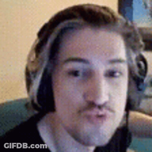 A Man Wearing Headphones And A Mustache Is Making A Funny Face . GIF