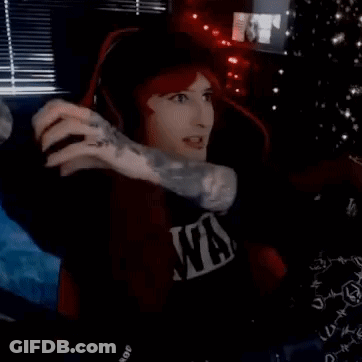 A Man Wearing Headphones And A Nirvana Shirt Is Sitting In A Dark Room . GIF