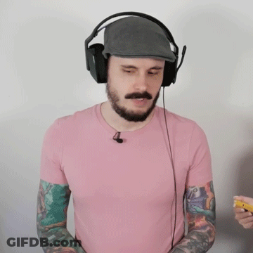 A Man Wearing Headphones And A Pink Shirt Has Tattoos On His Arms GIF