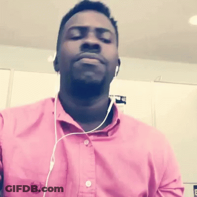A Man Wearing Headphones And A Pink Shirt With The Letter B On The Front GIF