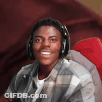 A Man Wearing Headphones And A Plaid Shirt Is Smiling GIF