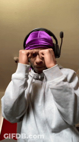 A Man Wearing Headphones And A Purple Headband Covering His Eyes GIF