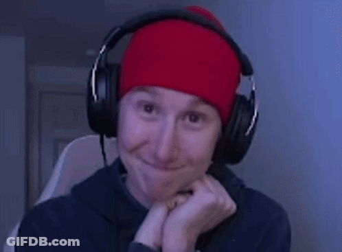 A Man Wearing Headphones And A Red Beanie Smiles GIF